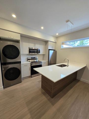 Ottawa apartment for rent - A modern kitchen with a white countertop and wooden flooring.