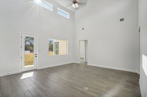Horseshoe Bay house for rent - A room with white walls and a wooden floor with a door on the left and a window on the right.