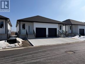 Aylmer townhouse for rent - A two-story house with a garage door and a door on the ground floor.