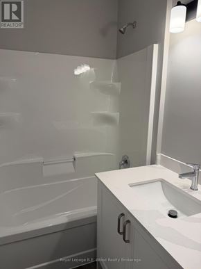 Aylmer townhouse for rent - A white bathroom with a sink and a glass shower stall.
