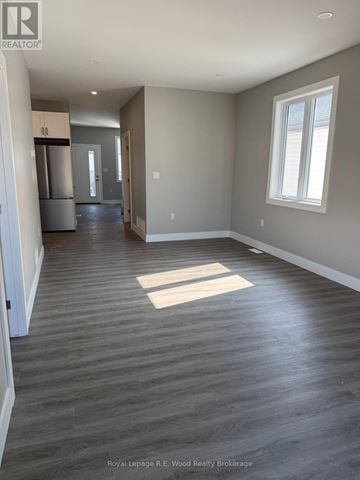 Aylmer townhouse for rent - A spacious room with wood flooring and a window.
