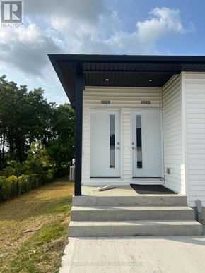 Aylmer townhouse for rent - A white house with a black roof and a glass door.