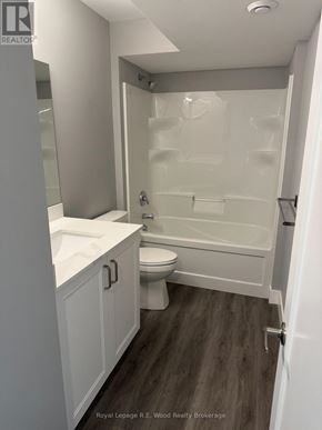 Aylmer townhouse for rent - A white bathroom with a toilet, sink, and bathtub.