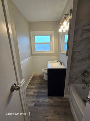 Florissant house for rent - A bathroom with a toilet, sink, and a window.