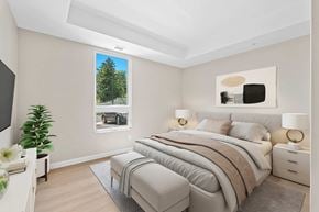 Napanee apartment for rent - A bedroom with a large bed and a picture of a tree on the wall.