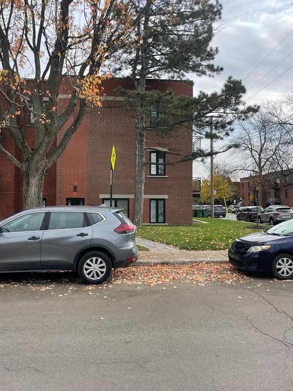 Montreal apartment for rent - A grey car is parked on the side of a street.