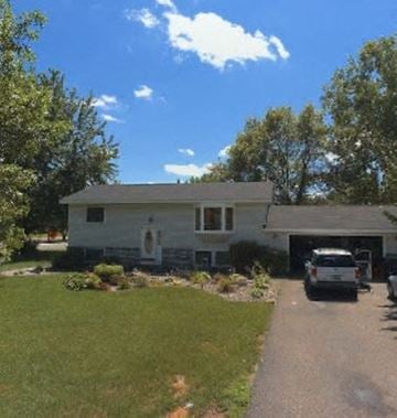Coon Rapids house for rent - A white house with a garage and a car parked in front.