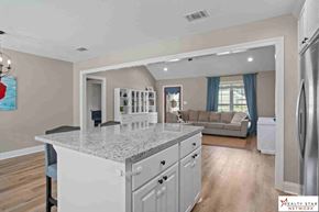 Purvis house for rent - A kitchen with a granite countertop and a refrigerator to the right.