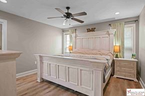Purvis house for rent - A bedroom with a large bed, a dresser, and a ceiling fan.
