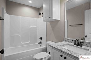 Purvis house for rent - A bathroom with a white tub, toilet, and sink.