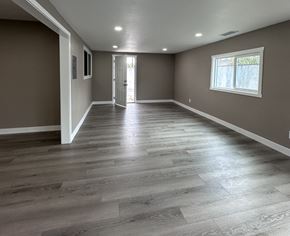 Ontario house for rent - A room with wooden flooring and a window on the right side.