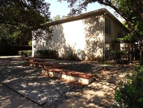 Dallas apartment for rent - A house with a concrete patio and a tree in front.