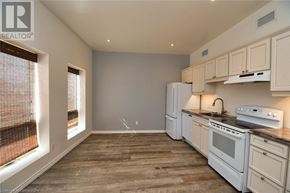 Hamilton apartment for rent - A kitchen with white appliances and wooden floors.