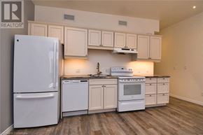 Hamilton apartment for rent - A white refrigerator is in a kitchen with white cabinets and a white stove.