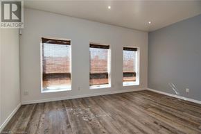 Hamilton apartment for rent - A room with wooden flooring and three windows.