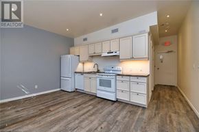Hamilton apartment for rent - A kitchen with white appliances and wooden floors.