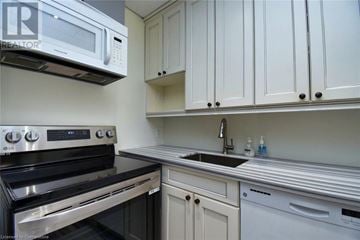 Hamilton apartment for rent - A kitchen with white cabinets and a black stove top oven.