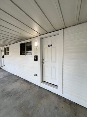Glassport house for rent - A white door with the number 820 on it is on the side of a building.