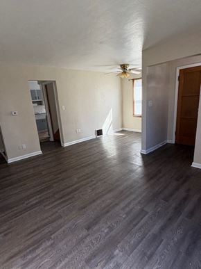 Lima house for rent - A room with a ceiling fan and wood flooring.