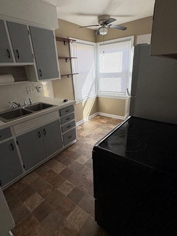 Lima house for rent - A kitchen with a black stove top oven and a fan on the ceiling.