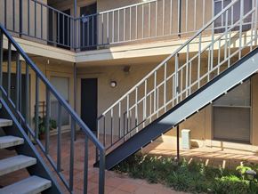 Dallas apartment for rent - A staircase with a metal railing leads to a balcony.