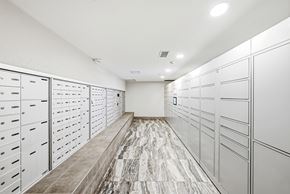 Hamilton apartment for rent - A long hallway with a marble floor and white lockers on both sides.