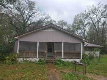 Deridder house for rent - A house with a brown roof and a white fence.