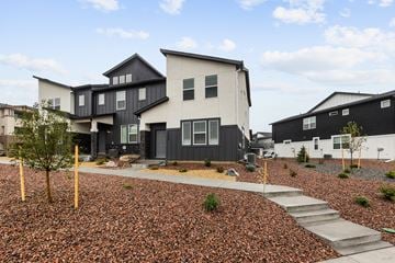 Colorado Springs house for rent - A modern house with a black and white exterior and a gravel garden in front.