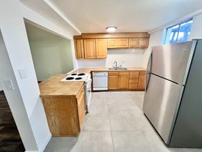 Arvada apartment for rent - A house with a red brick exterior and a white door is surrounded by a grassy area and a sidewalk.