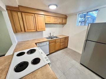Arvada apartment for rent - A kitchen with a stove top oven and a refrigerator.