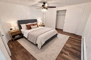 Arvada apartment for rent - A bedroom with a bed, nightstand, and a ceiling fan.