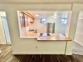 Arvada apartment for rent - A kitchen with a stove top oven and a fridge.
