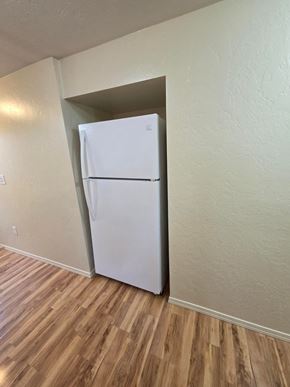 Boise triplex for rent - A white refrigerator in a room with wooden flooring.