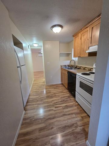 Boise triplex for rent - A kitchen with wooden floors and white appliances.