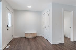 Edmonton apartment for rent - A room with white walls and a wooden floor with a bench in the middle.