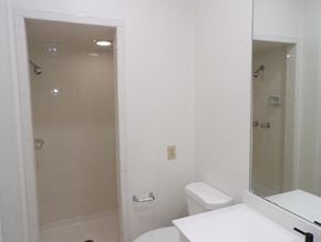 Dallas apartment for rent - A white bathroom with a toilet, sink, and shower.