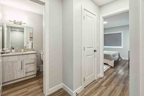 Fort Saskatchewan apartment for rent - A small bedroom with a bed, dresser, and mirror.