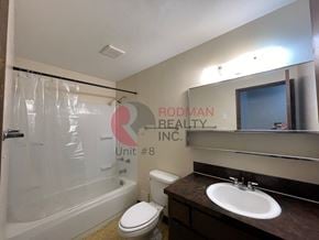 Longview apartment for rent - A bathroom with a toilet, sink, and mirror.