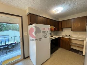 Longview apartment for rent - A kitchen with a refrigerator that says "RODIN REAL INC Unit #8".