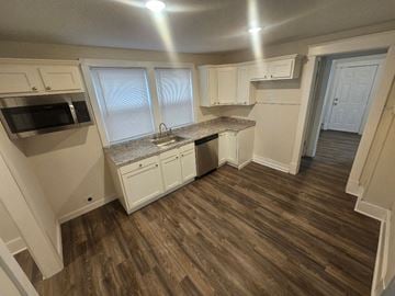 Lima house for rent - A kitchen with white cabinets and a microwave.