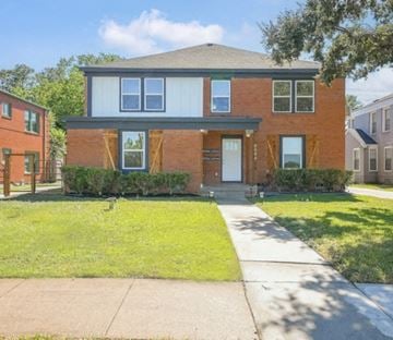 Houston apartment for rent - A two-story brick house with a front porch.