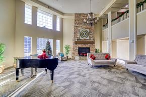 Aurora apartment for rent - A living room with a piano, a fireplace, and a couch.