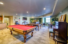 Aurora apartment for rent - A pool table is in the middle of a room with chairs and a bar.