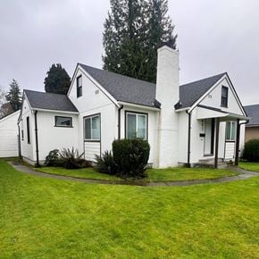 Longview house for rent - A white house with a black roof and a chimney.