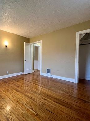 Longview house for rent - A room with wooden floors and a white door.