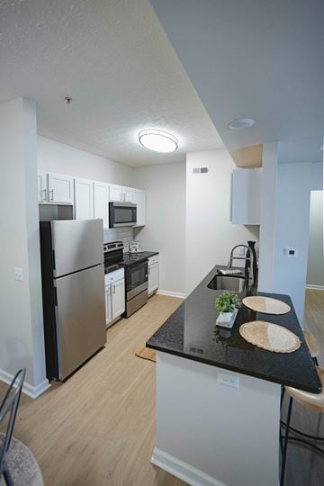 Westerville apartment for rent - A living room with a grey couch, a grey chair and a coffee table.