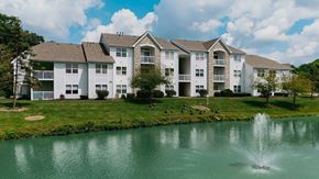 Westerville apartment for rent - A large swimming pool in front of a house with a stone chimney.