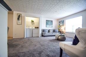 Westerville apartment for rent - A bedroom with a bed, chair, and painting on the wall.