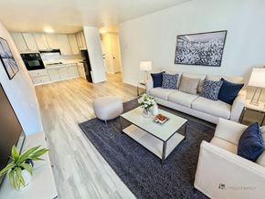 Denver apartment for rent - A sunny room with white chairs and a grey carpet.