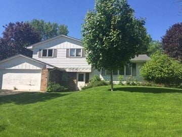 New Brighton house for rent - A house with a white garage door and a tree in front.